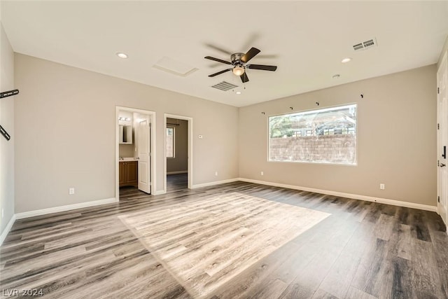 unfurnished bedroom with hardwood / wood-style flooring, ceiling fan, and ensuite bath