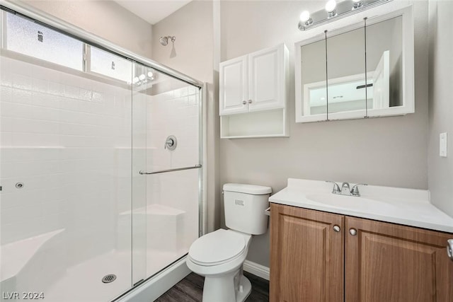 bathroom with vanity, wood-type flooring, a shower with shower door, and toilet