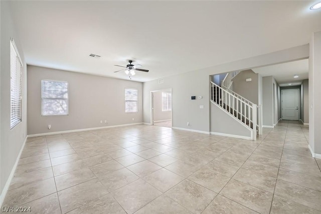 tiled empty room featuring a wealth of natural light and ceiling fan