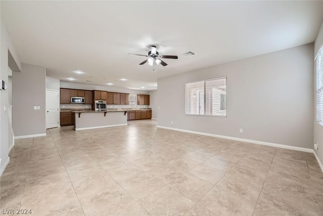 unfurnished living room with ceiling fan