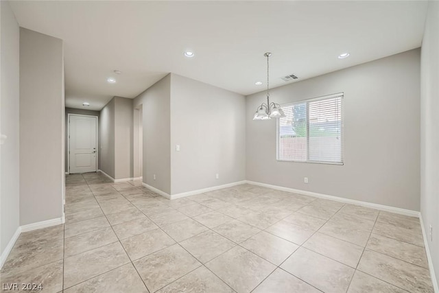 spare room with light tile patterned floors and a chandelier