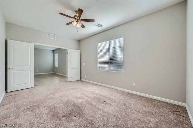 unfurnished bedroom featuring light colored carpet and ceiling fan