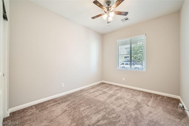 carpeted spare room featuring ceiling fan