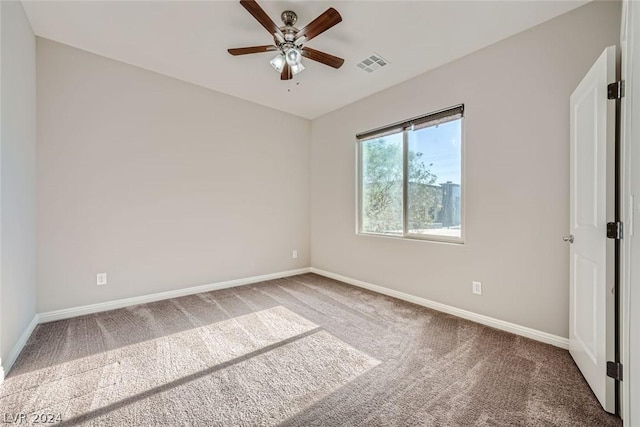 spare room with ceiling fan and carpet