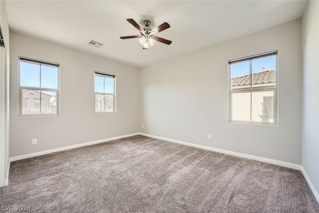 carpeted spare room featuring ceiling fan