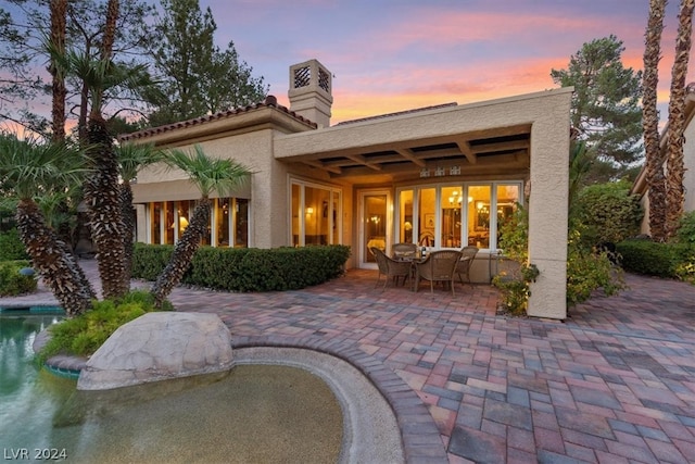 back house at dusk with a patio