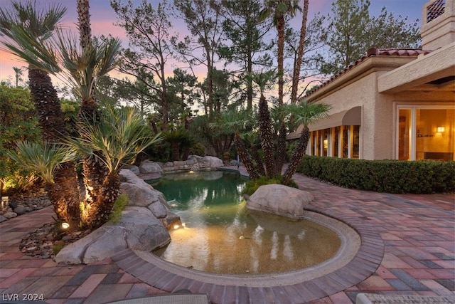 pool at dusk with a patio