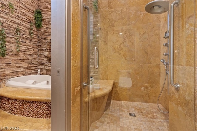 bathroom featuring independent shower and bath