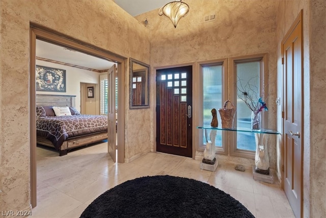 entryway featuring a towering ceiling and light tile patterned floors