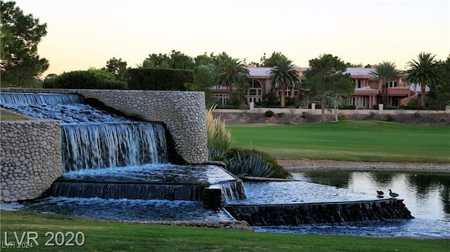 view of home's community with a yard and a water view