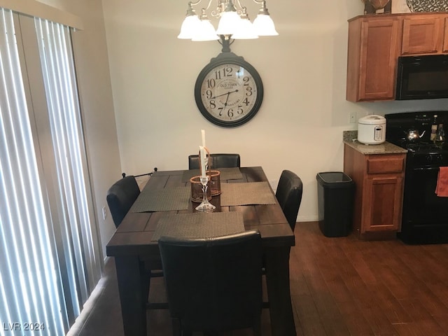 dining room with dark wood-type flooring and a chandelier