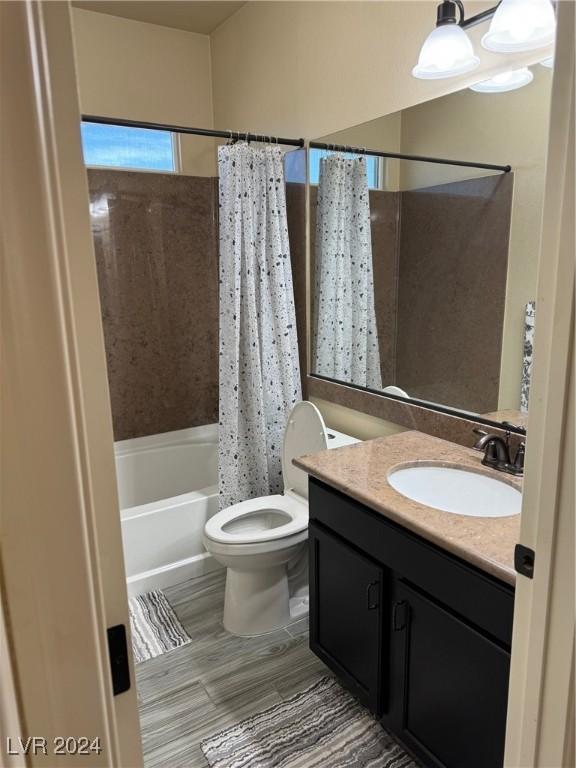 bathroom with shower / bath combo, vanity, and toilet