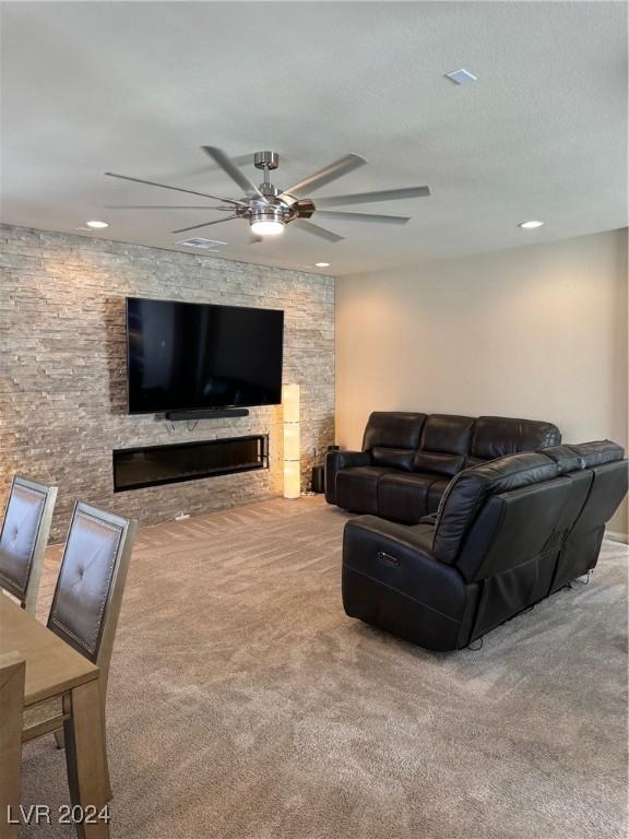 carpeted living room featuring ceiling fan, a glass covered fireplace, and recessed lighting