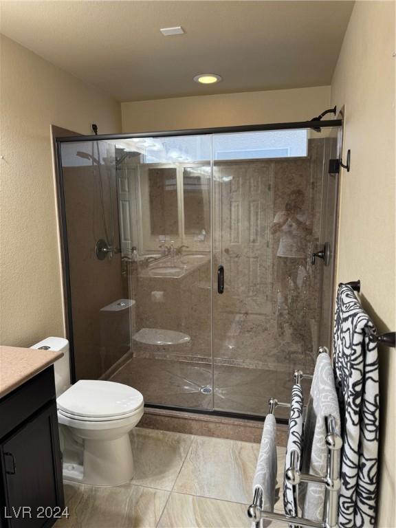 full bath featuring a stall shower, vanity, and toilet