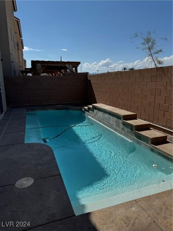 view of swimming pool with a fenced backyard and a fenced in pool