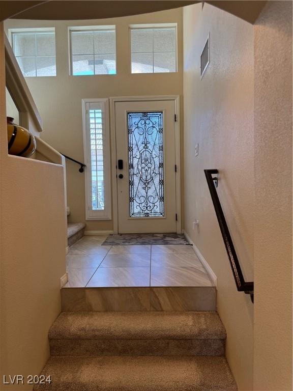 tiled foyer featuring stairs and visible vents