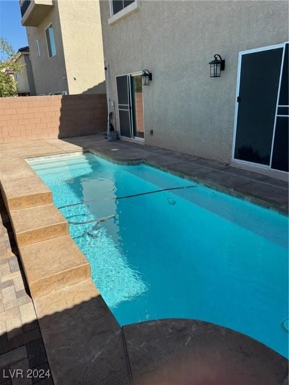 view of swimming pool featuring a fenced in pool and fence