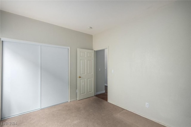 unfurnished bedroom featuring carpet floors and a closet