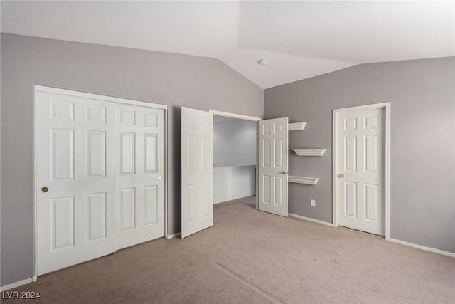 unfurnished bedroom with vaulted ceiling and light carpet