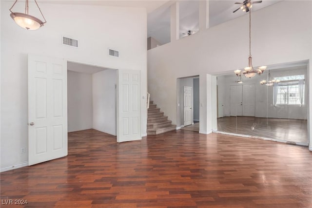 unfurnished living room with an inviting chandelier, dark hardwood / wood-style floors, and vaulted ceiling