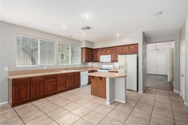 kitchen with sink, light tile patterned floors, white appliances, and a center island