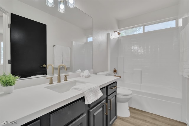 full bathroom with vanity, hardwood / wood-style flooring, shower / tub combination, and toilet