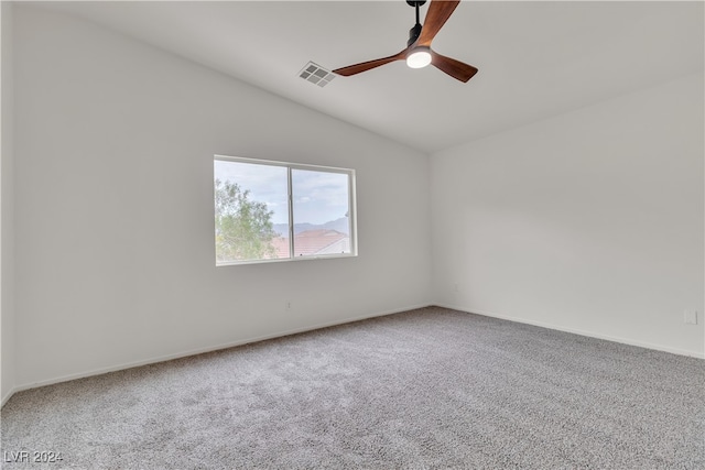 spare room featuring ceiling fan, carpet flooring, and vaulted ceiling