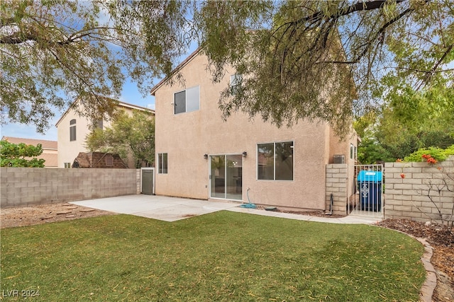 rear view of house with a patio and a lawn