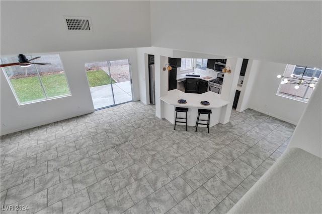 living room featuring a towering ceiling and ceiling fan