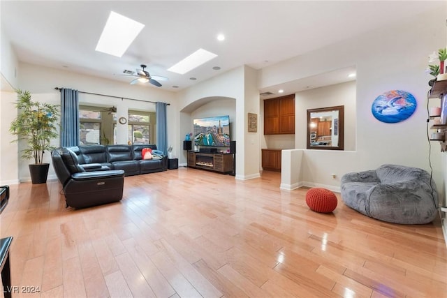 living room featuring a skylight and light wood-type flooring