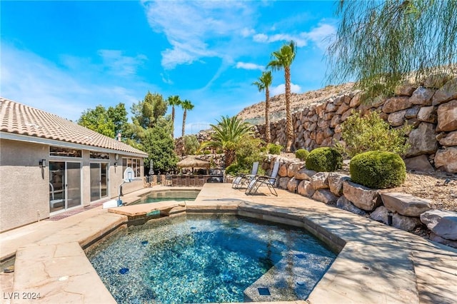 view of pool featuring a patio area and an in ground hot tub