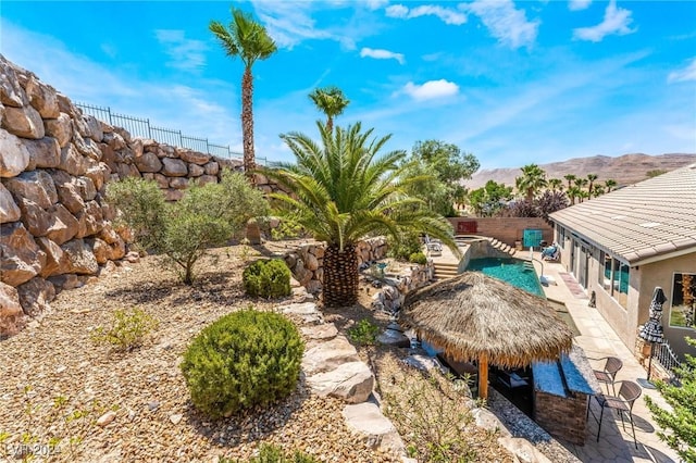 view of yard with a mountain view, a gazebo, a patio area, and a fenced in pool