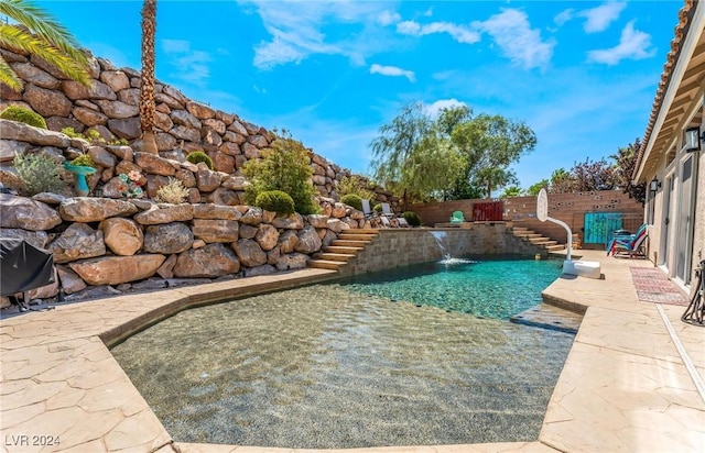 view of pool with pool water feature and a patio area