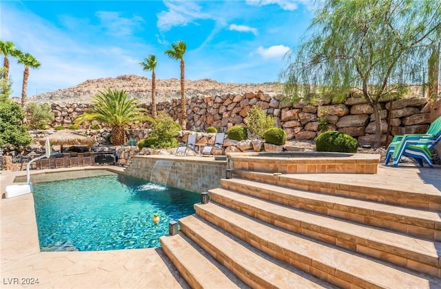 view of swimming pool featuring a patio, pool water feature, and a mountain view