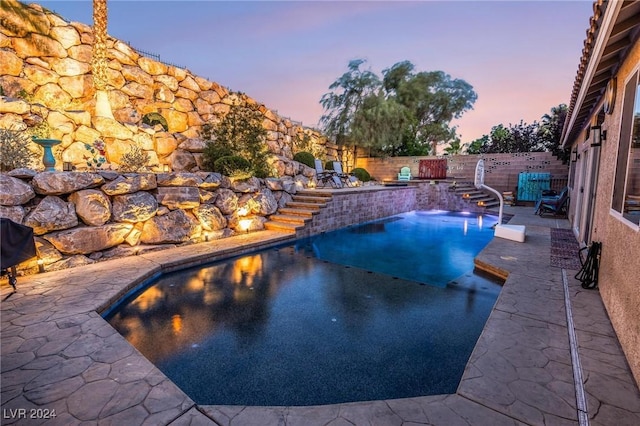 pool at dusk featuring a patio area