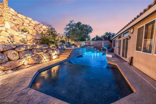 pool at dusk with a patio