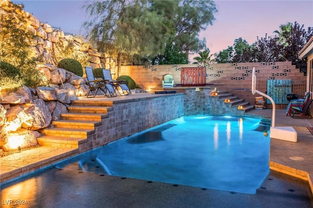 pool at dusk featuring a patio area