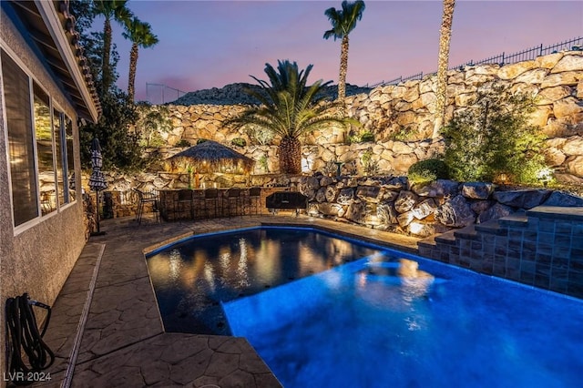 pool at dusk with a patio