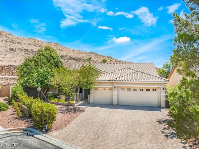 view of front of home with a mountain view and a garage