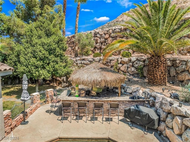 view of patio / terrace with exterior bar and a grill