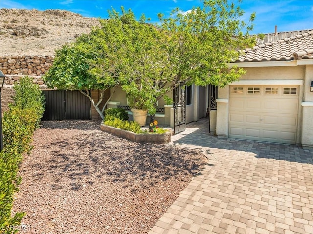 view of property hidden behind natural elements with a garage