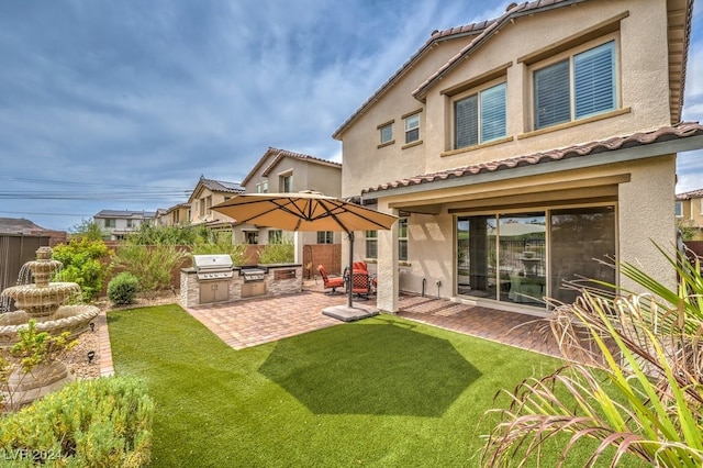 rear view of house featuring exterior kitchen and a patio area