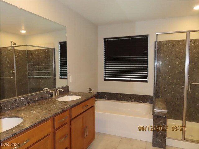 bathroom featuring dual vanity, shower with separate bathtub, and tile patterned flooring