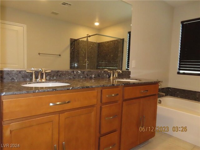 bathroom with double vanity, tile patterned flooring, and separate shower and tub