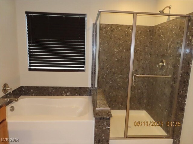 bathroom featuring separate shower and tub