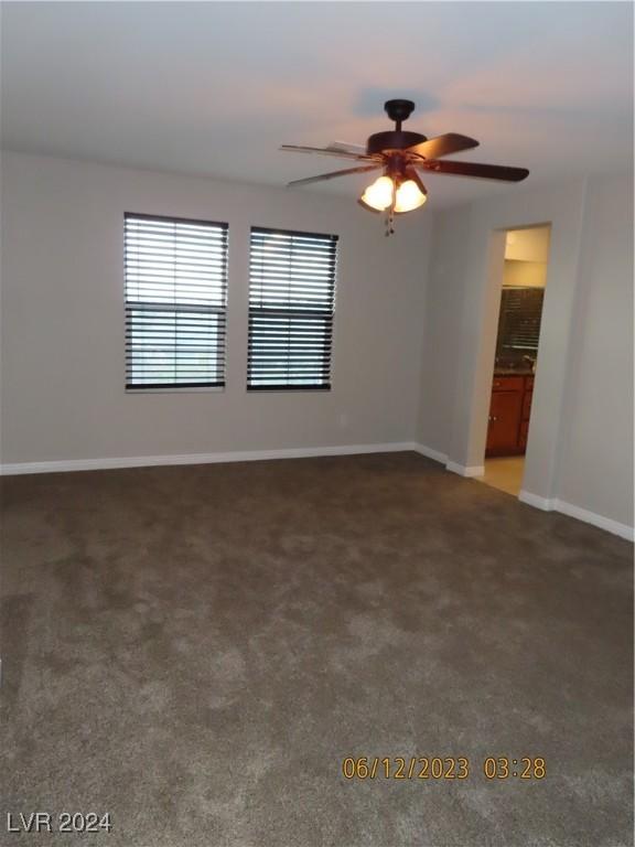 carpeted spare room featuring ceiling fan