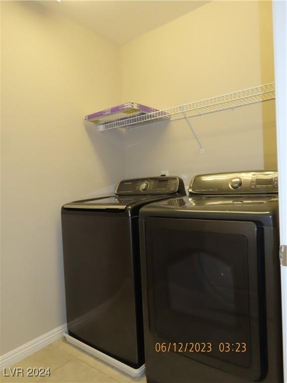 laundry room featuring separate washer and dryer and light tile patterned flooring