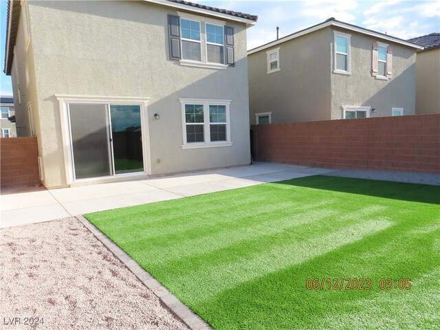 rear view of property featuring a patio and a yard