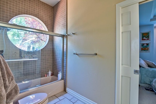 bathroom featuring toilet and combined bath / shower with glass door