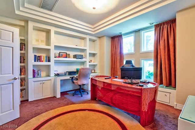 office area with carpet flooring, a tray ceiling, and built in features